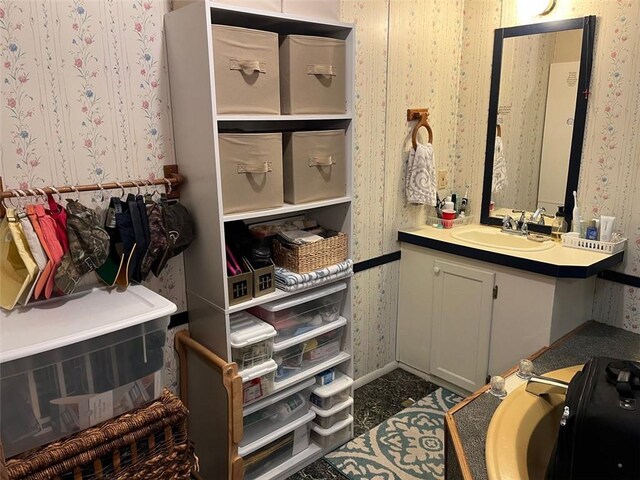 bathroom with wallpapered walls and vanity