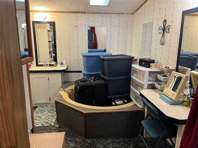 interior space featuring ornamental molding, a sink, a textured ceiling, and wallpapered walls