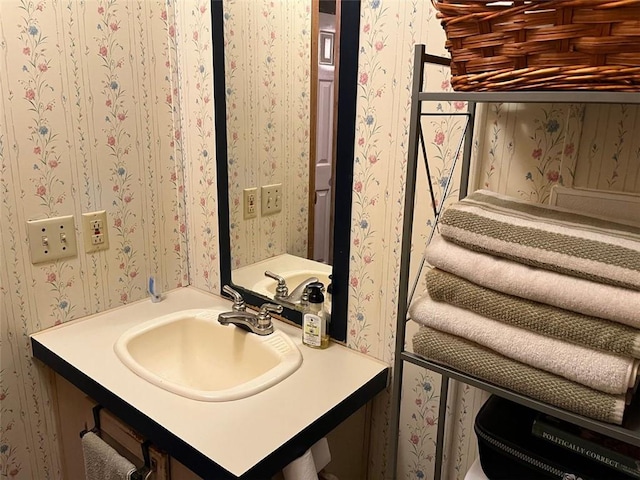 bathroom featuring wallpapered walls and a sink