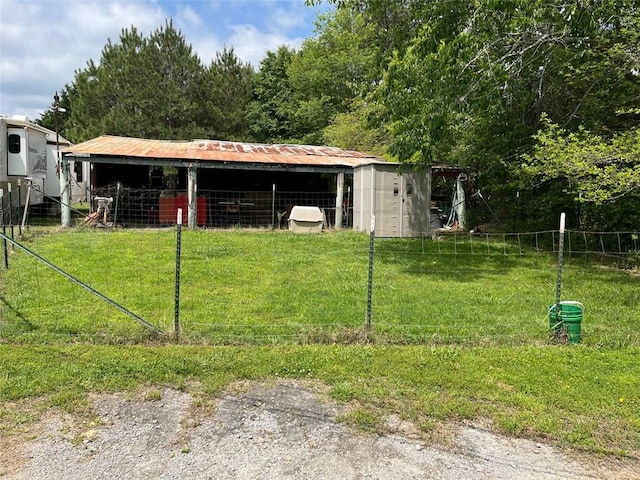 view of pole building featuring fence and a lawn