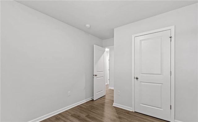 unfurnished bedroom with dark wood-type flooring