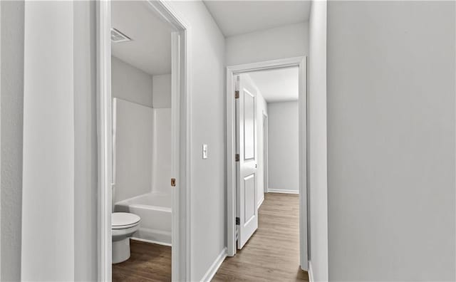 hallway with light hardwood / wood-style floors