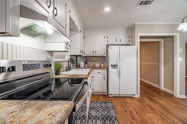 kitchen with sink, stainless steel range with electric stovetop, light wood-type flooring, white fridge with ice dispenser, and white cabinets