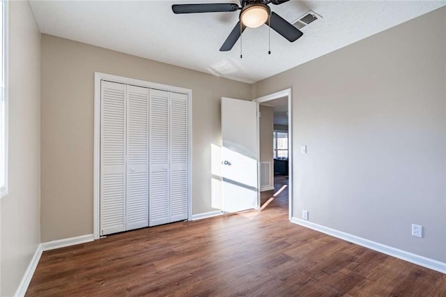 unfurnished bedroom with wood-type flooring, ceiling fan, and a closet