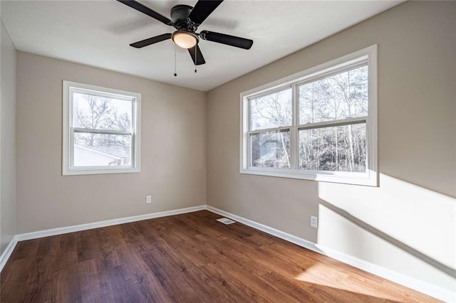 spare room featuring dark wood-type flooring and ceiling fan