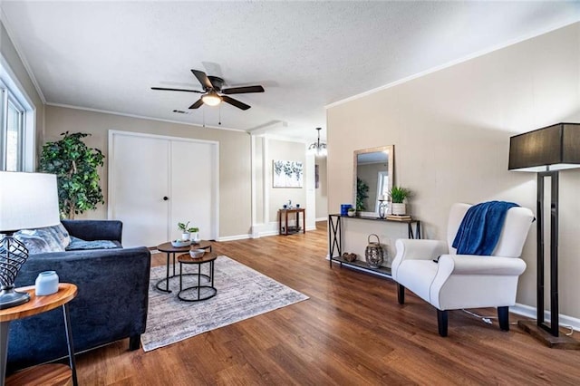 living room with crown molding, hardwood / wood-style floors, a textured ceiling, and ceiling fan