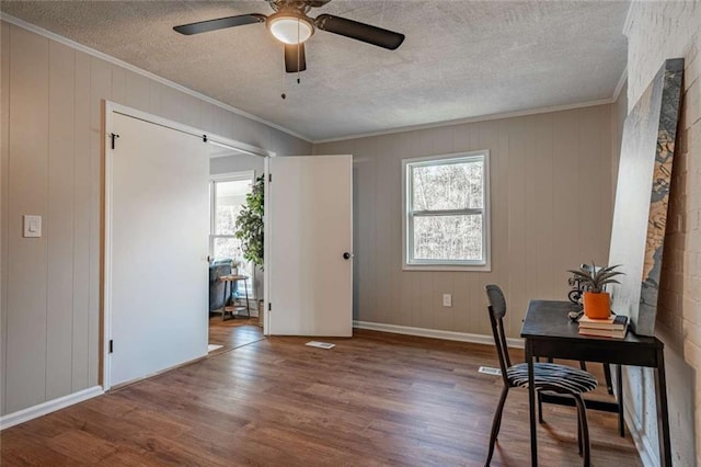 office featuring ceiling fan, ornamental molding, wood-type flooring, and a textured ceiling