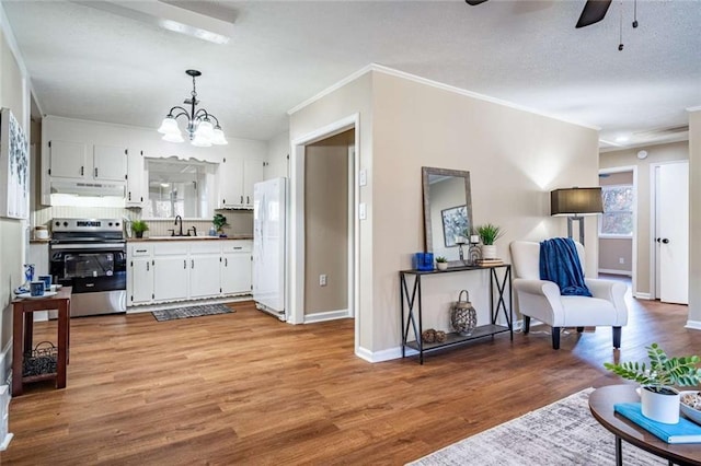 kitchen with pendant lighting, white cabinetry, sink, stainless steel range with electric cooktop, and white fridge