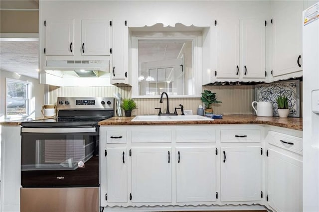 kitchen with sink, electric range, and white cabinets