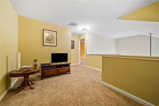 interior space with baseboards, visible vents, a textured ceiling, and light colored carpet