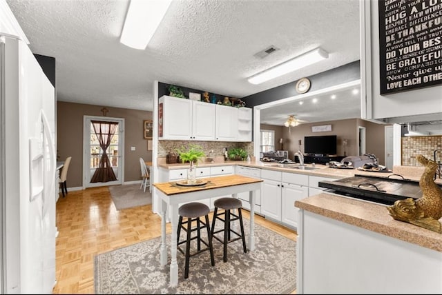 6045 Mockingbird Rd, Cumming, GA 30028 - kitchen featuring a textured ceiling, backsplash, white appliances, and a sink