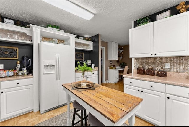 6045 Mockingbird Rd, Cumming, GA 30028 - kitchen featuring white fridge with ice dispenser, a textured ceiling, open shelves, decorative backsplash, and white cabinets