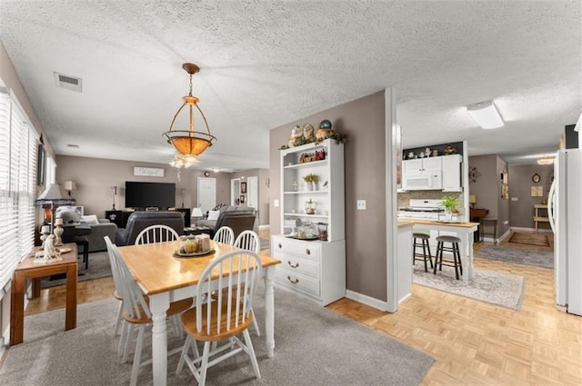 6045 Mockingbird Rd, Cumming, GA 30028 - dining space with a textured ceiling, visible vents, and baseboards