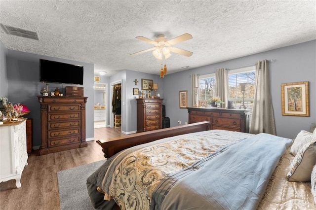 6045 Mockingbird Rd, Cumming, GA 30028 - bedroom with wood finished floors, a textured ceiling, visible vents, a ceiling fan, and baseboards