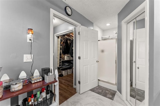 6045 Mockingbird Rd, Cumming, GA 30028 - bathroom with a shower stall, a spacious closet, and a textured ceiling