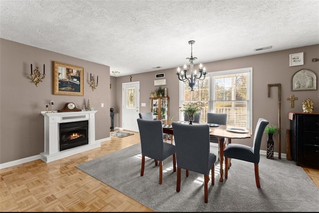 6045 Mockingbird Rd, Cumming, GA 30028 - dining space with a textured ceiling, visible vents, baseboards, and a notable chandelier