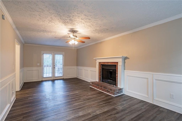 unfurnished living room with dark wood-type flooring, a fireplace, a textured ceiling, crown molding, and ceiling fan