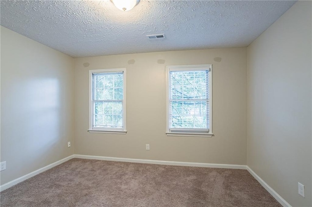 carpeted spare room with a textured ceiling