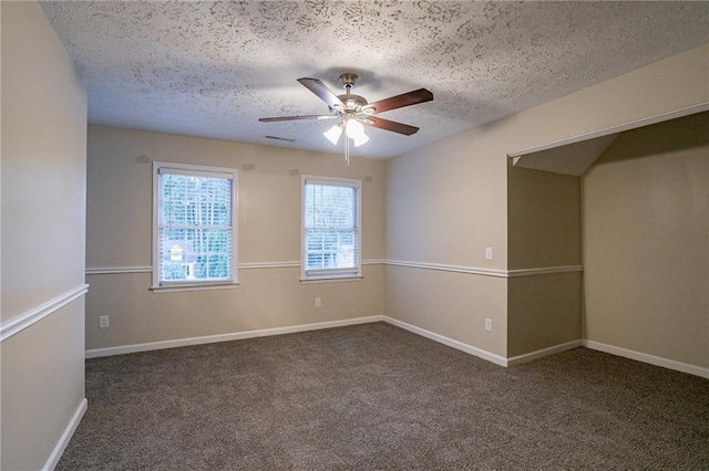 carpeted spare room featuring a textured ceiling and ceiling fan