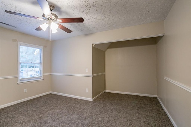 carpeted spare room featuring a textured ceiling and ceiling fan