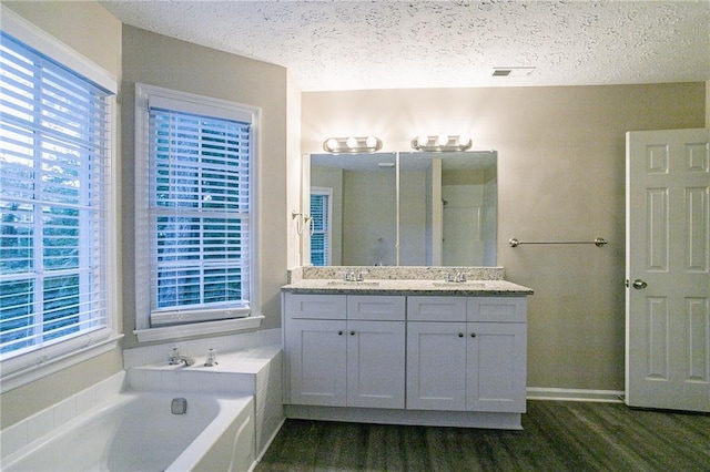 bathroom with vanity, a textured ceiling, independent shower and bath, and hardwood / wood-style floors