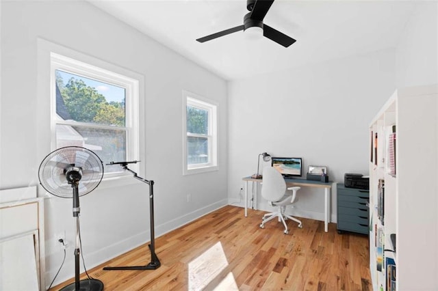 home office featuring light wood-style floors, ceiling fan, and baseboards