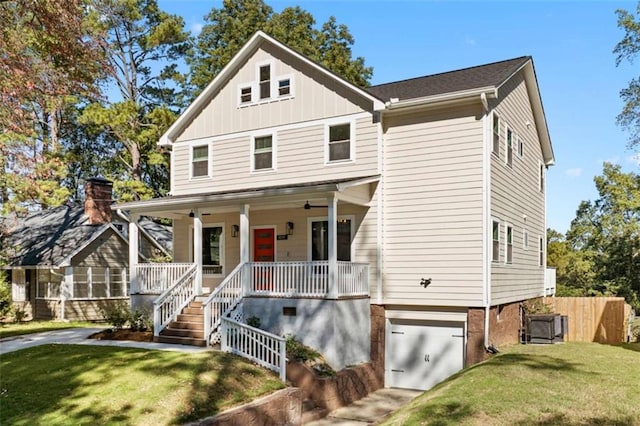 view of front of home featuring a garage, covered porch, a front lawn, and board and batten siding