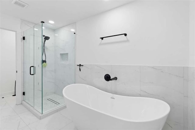 bathroom featuring marble finish floor, visible vents, a freestanding tub, and a marble finish shower