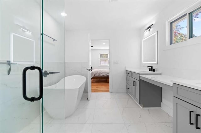 bathroom with marble finish floor, a shower stall, and vanity