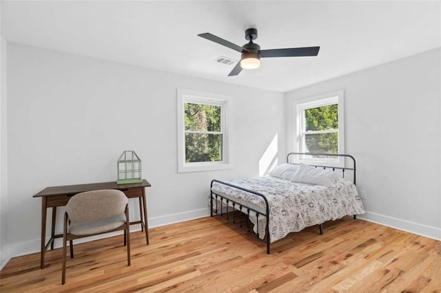 bedroom with light wood finished floors, baseboards, and visible vents