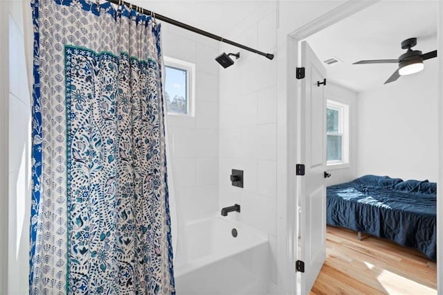 full bath featuring shower / tub combo, visible vents, ceiling fan, and wood finished floors