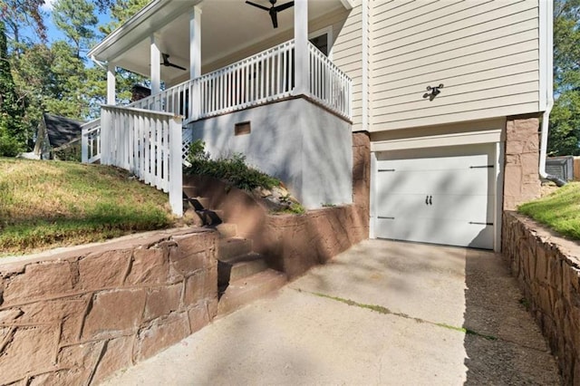 view of side of home featuring a garage, covered porch, driveway, and ceiling fan