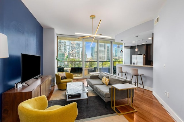 1080 Peachtree St NE Unit 608, Atlanta, GA 30309 - living room with light wood-style floors, baseboards, and expansive windows