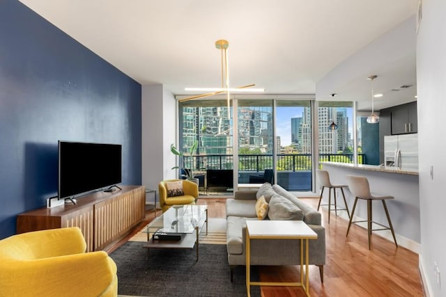 1080 Peachtree St NE Unit 608, Atlanta, GA 30309 - living area with a wall of windows, wood finished floors, and baseboards