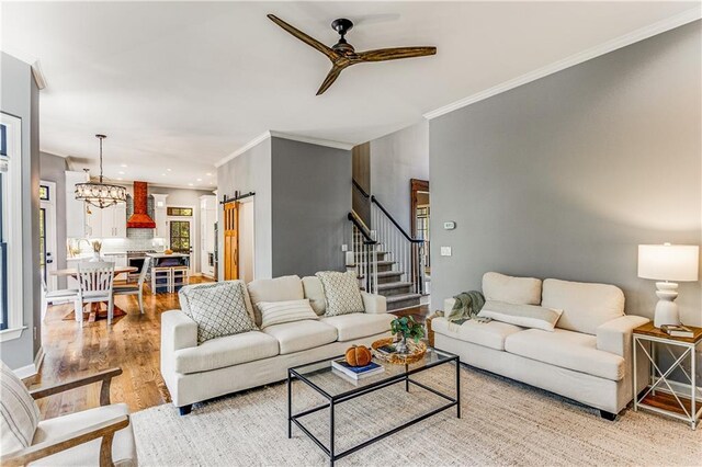 51 River Overlook Ct, Dawsonville, GA 30534 - living room featuring ceiling fan, ornamental molding, light wood-style floors, stairway, and a chandelier