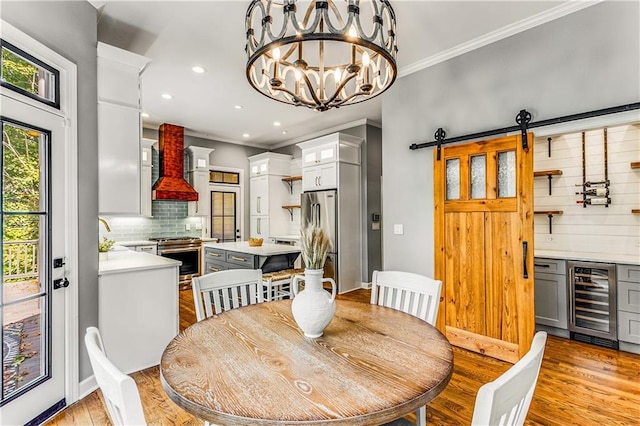 51 River Overlook Ct, Dawsonville, GA 30534 - dining area with beverage cooler, crown molding, light wood-style flooring, recessed lighting, and a barn door