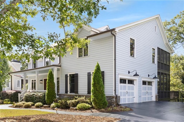 51 River Overlook Ct, Dawsonville, GA 30534 - view of side of home with concrete driveway, a garage, a porch, and stone siding