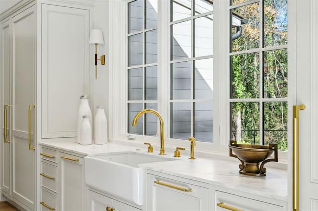 interior space featuring light stone counters, plenty of natural light, and sink