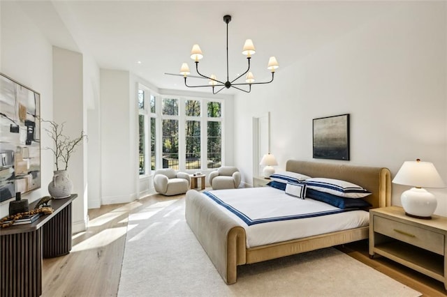 bedroom with a notable chandelier and light wood-type flooring