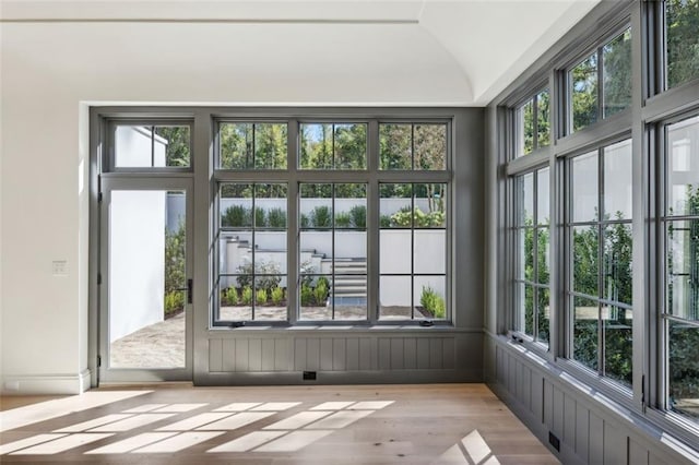 unfurnished sunroom featuring a wealth of natural light and lofted ceiling