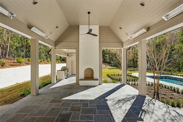 view of patio with ceiling fan, a grill, a fireplace, and an outdoor kitchen