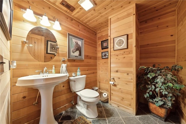 bathroom with wooden walls, wooden ceiling, and toilet