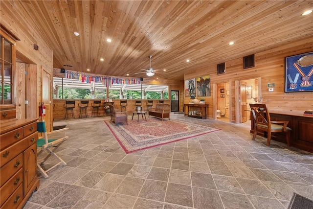 interior space with ceiling fan, wooden walls, and wood ceiling