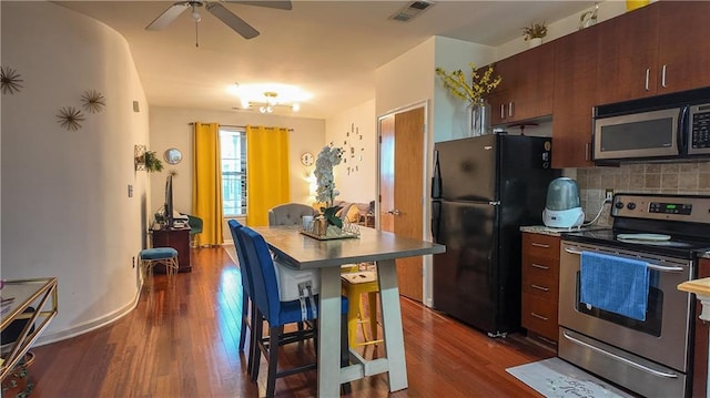 kitchen with dark wood-style floors, visible vents, backsplash, and stainless steel appliances