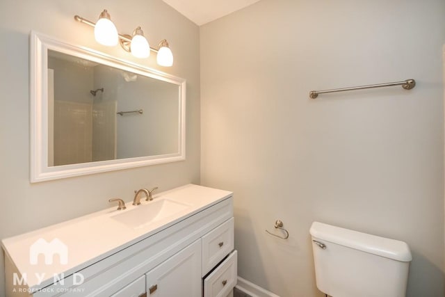 bathroom featuring vanity, toilet, and a shower