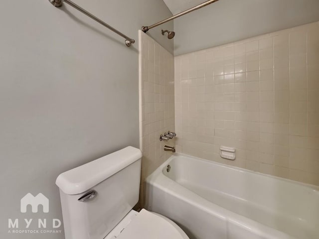 bathroom featuring toilet and tiled shower / bath