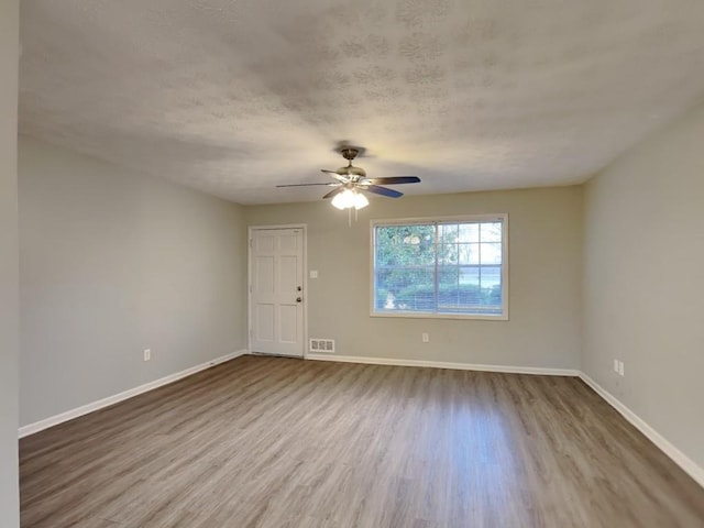 unfurnished room featuring hardwood / wood-style floors, a textured ceiling, and ceiling fan