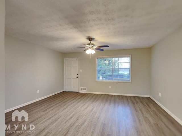 spare room with hardwood / wood-style flooring, ceiling fan, and a textured ceiling