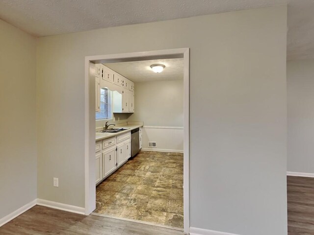 unfurnished room with ceiling fan, wood-type flooring, and a textured ceiling