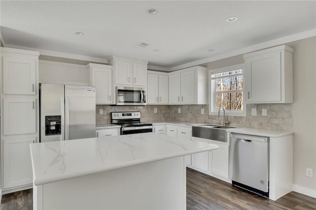 kitchen with a center island, stainless steel appliances, and white cabinetry